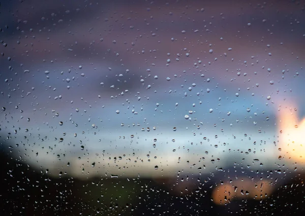 窗玻璃上的雨滴 可以看到夜市的灯光 — 图库照片