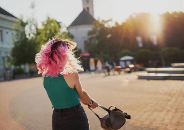 ピンク色の髪をしたスタイリッシュな若い女性は人生を楽しんでいます 日没時に街の渦 — ストック写真
