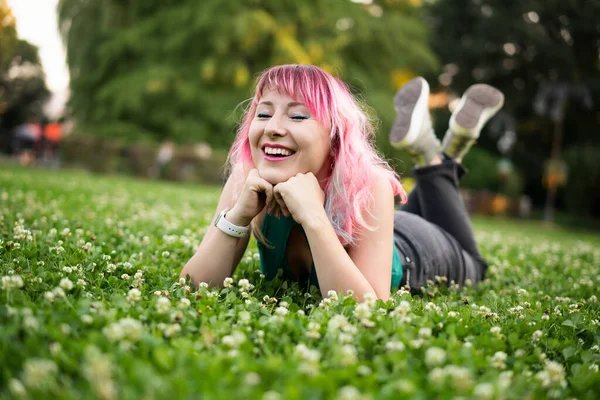 Stylowa Młoda Uśmiechnięta Kobieta Wielobarwnymi Różowymi Włosami Leżąca Zielonej Trawie — Zdjęcie stockowe