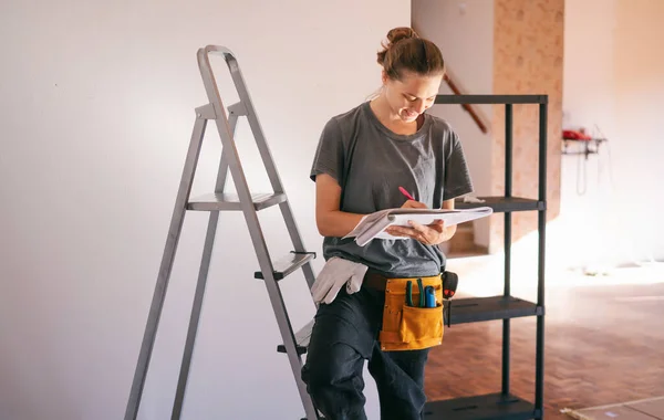 Beautiful Young Woman Professional Repairman Standing Next Stepladder Taking Notes — Stock Photo, Image