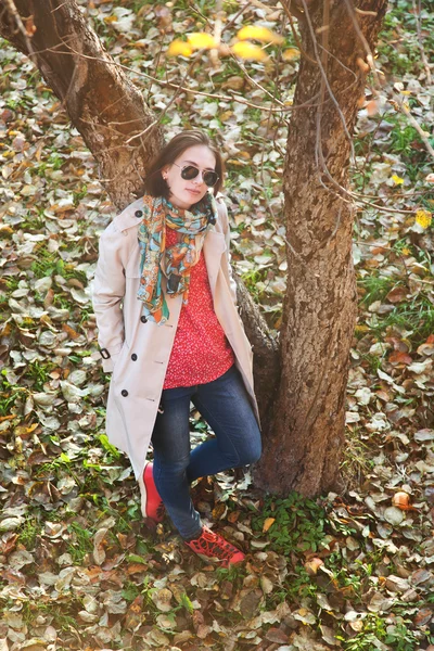 Mädchen im Herbstpark steht an Baum — Stockfoto