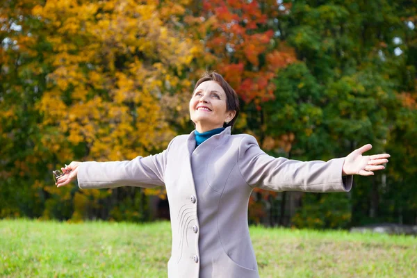 Attractive woman 50 years in the autumn park — Stock Photo, Image