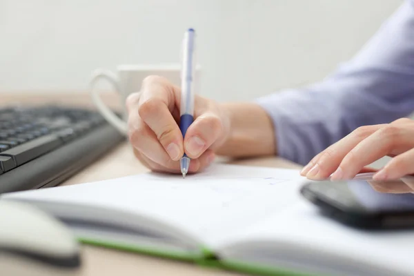 Close-up of female hands making notes in the notepad — Stock Photo, Image