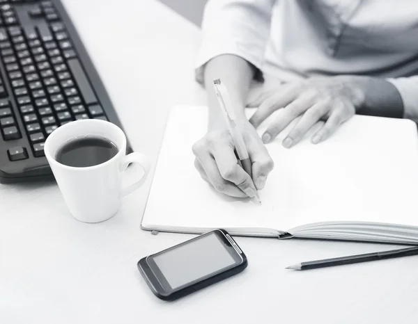 Gros plan des mains féminines prenant des notes dans le bloc-notes — Photo