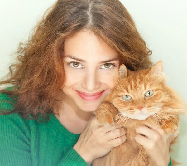 Schöne junge Frau mit einer roten flauschigen Katze — Stockfoto