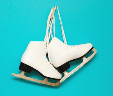 white ice skates for figure skating, hanging on a blue backgroun clipart