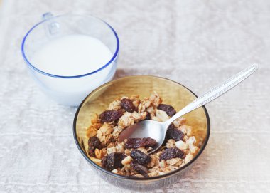 kurutulmuş meyve bir kase ve bir bardak süt ile müsli