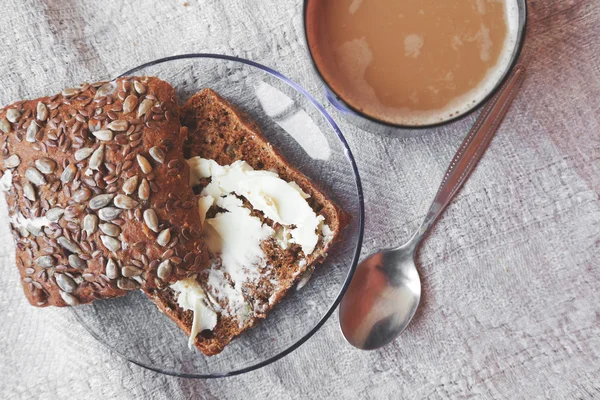 Grain rye bread and butter and cup of coffee — Stock Photo, Image