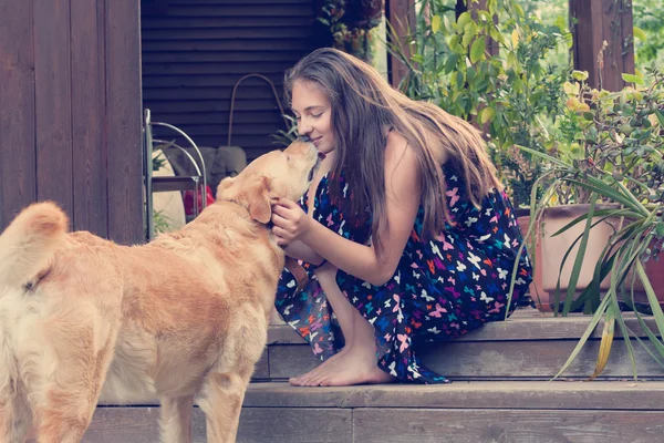 Bela jovem mulher beijando seu cão labrador — Fotografia de Stock