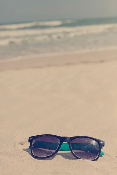Okulary w piasek na brzegu morza. czas wakacji — Zdjęcie stockowe