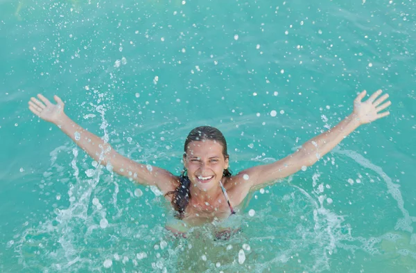 Menina feliz salpicando na água — Fotografia de Stock