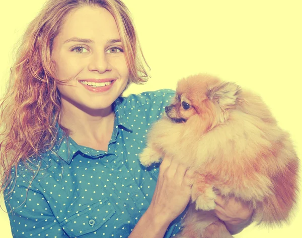 Jovem mulher com um pomerano em seus braços — Fotografia de Stock