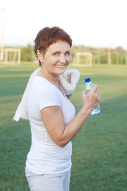 kadın 50 yıl bir şişe su, açık havada spor
