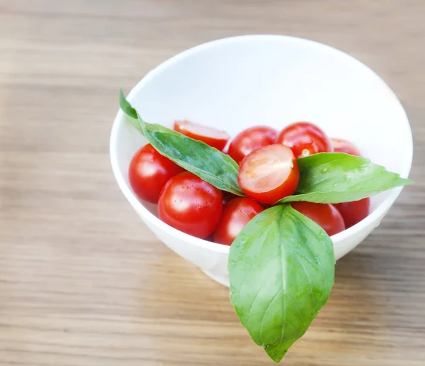Tomates cherry, albahaca y queso mozzarella en un plato —  Fotos de Stock