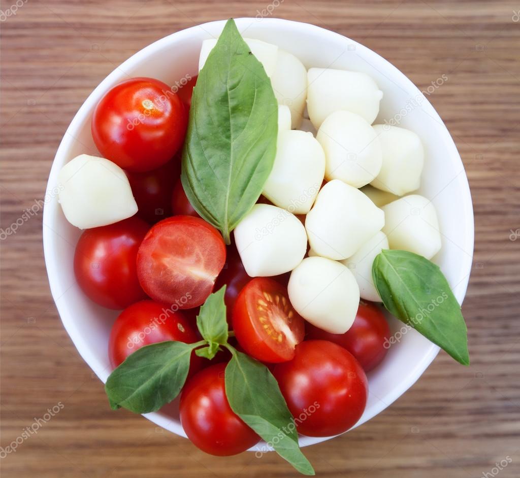 cherry tomatoes, basil and mozzarella cheese on a plate