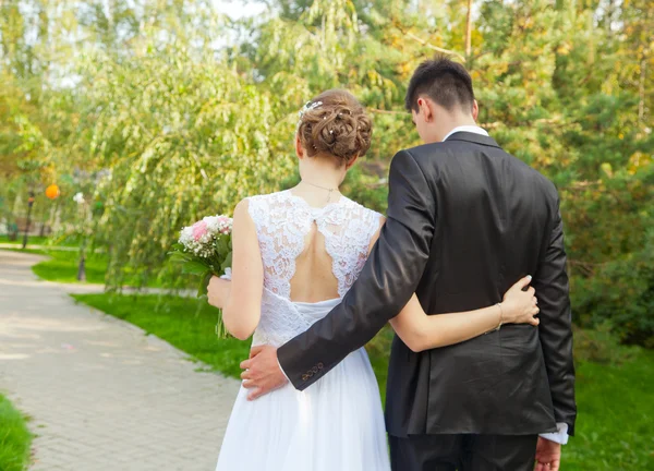 Bride and groom are holding each other by the waist — Stock Photo, Image
