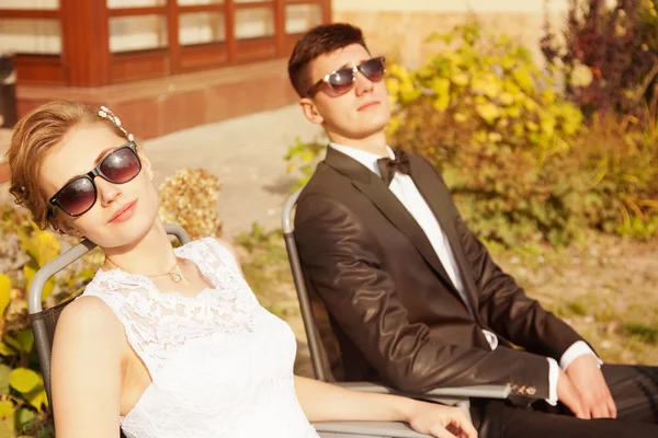 Trendy bride and groom in sun glasses — Stock Photo, Image