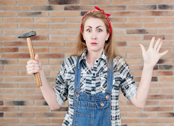 Attractive young woman with a hammer and a screwdriver, and on t — Stock Photo, Image