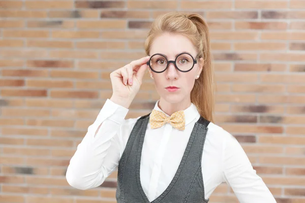 Atraente jovem mulher no colete e laço gravata usando óculos — Fotografia de Stock