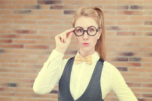 Atrakcyjna młoda kobieta w kamizelkę i muszka w okularach — Zdjęcie stockowe