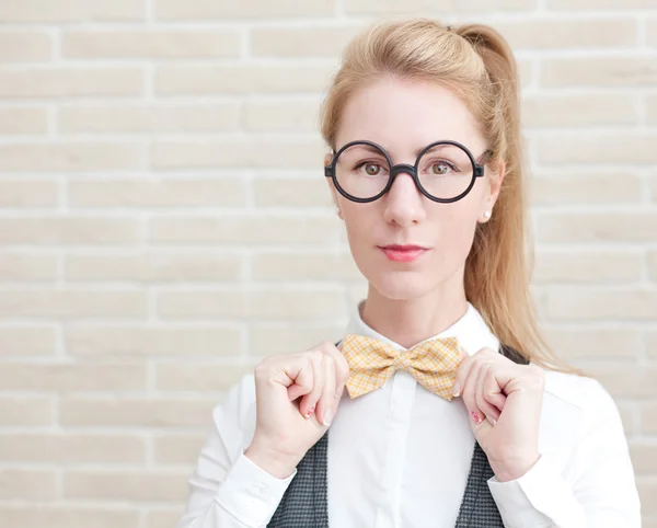 Atraente jovem mulher no colete e laço gravata usando óculos — Fotografia de Stock