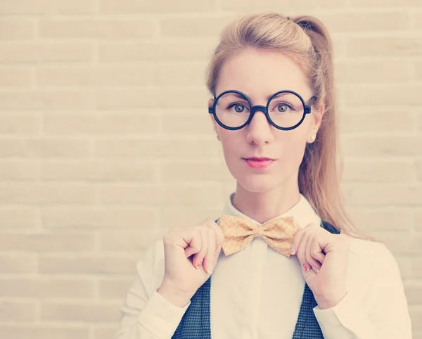 Atractiva mujer joven en chaleco y corbata de lazo con gafas — Foto de Stock