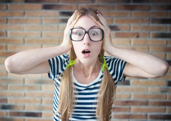 Funny young woman with braces on his teeth on the brick wall bac — Stock Photo, Image