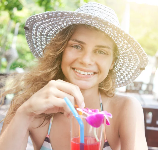 Vackra leende ung kvinna i solglasögon med en cocktail — Stockfoto