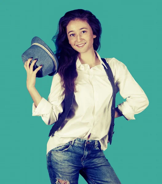 Söt flicka i vit skjorta, väst och hatt på en blå bakgrunds — Stockfoto