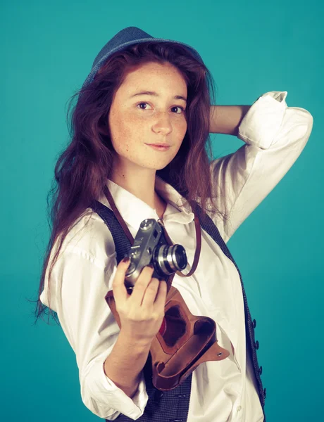 Hübsches Mädchen mit Retro-Kamera in den Händen auf blauem Hintergrund — Stockfoto