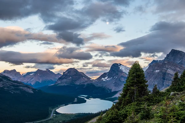 Uma lua cheia paira sobre Bow Lake e Medicine Bow Peak em Banff N Fotografia De Stock