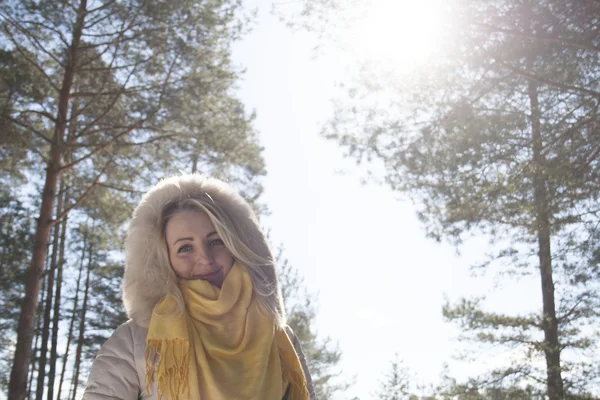 Блондинка в зимовому лісі проти неба — стокове фото