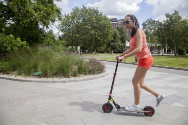 kız yaz Park ile bir scooter sürme