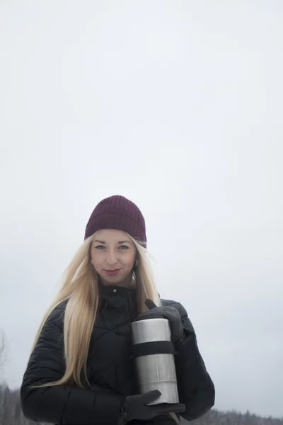 Meisje in een rode hoed op een achtergrond van bos landschap — Stockfoto