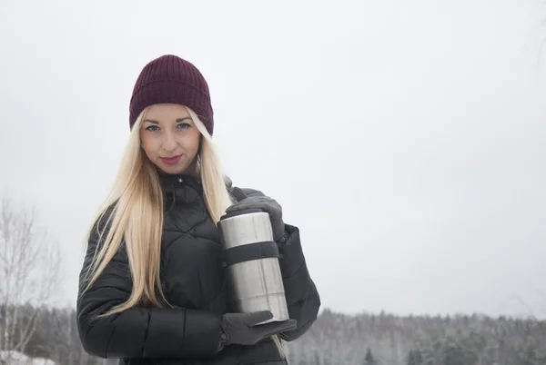 Meisje in een rode hoed op een achtergrond van bos landschap — Stockfoto