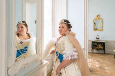 aynaya bakarak eski elbiseli kadın 