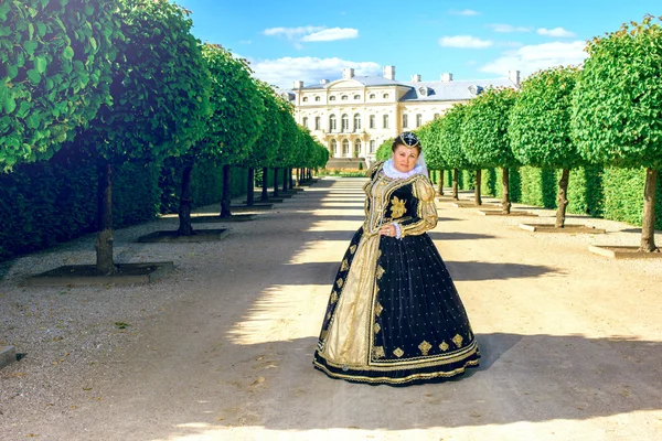 Woman in ancient dress walking  in the garden — Stock Photo, Image