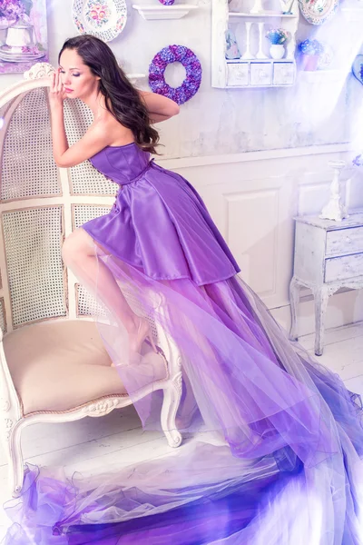 Женщина позирует в длинном фиолетовом платье — стоковое фото