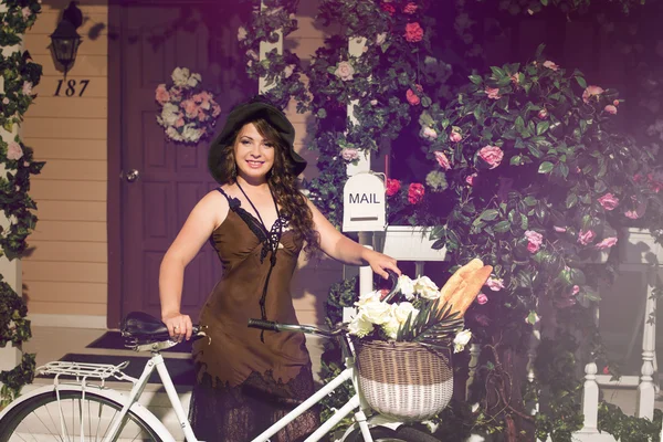 Mulher bonita de pé perto de bicicleta retro — Fotografia de Stock