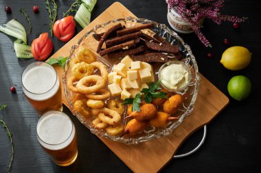 Bira ve aperatifler arka planda bir tabakta, kapat