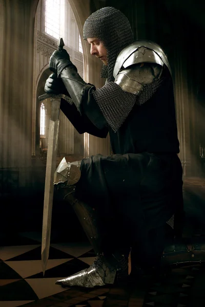 Ancient knight standing on one knee — Stock Photo, Image