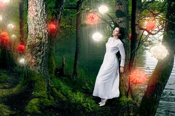 Frau im weißen Kleid spaziert im Märchenwald — Stockfoto