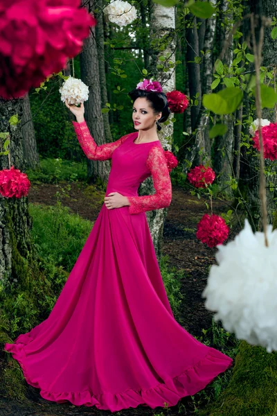 Mujer en vestido largo de color rosa en la madera —  Fotos de Stock