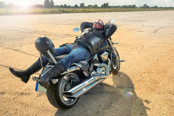 Motociclista descansando em uma motocicleta — Fotografia de Stock