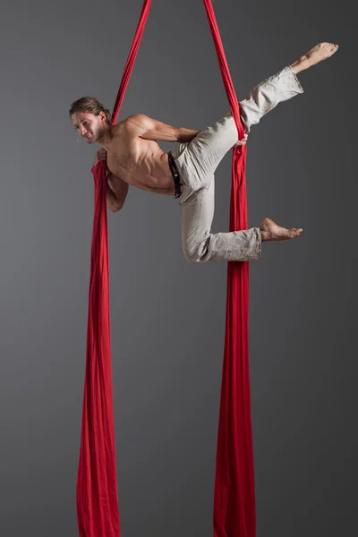 Homem realizando dança de seda aérea — Fotografia de Stock