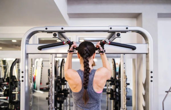 Vrouw in sportschool buigen rugspieren — Stockfoto