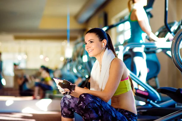 Fitte Frau im Fitnessstudio mit Smartphone — Stockfoto