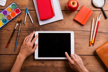 Elle tablet ve okul malzemeleri.