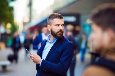 Hipster Yöneticisi holding smartphone dışında