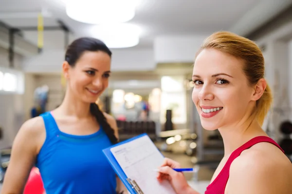 Frau im Fitnessstudio mit Personal Trainer — Stockfoto